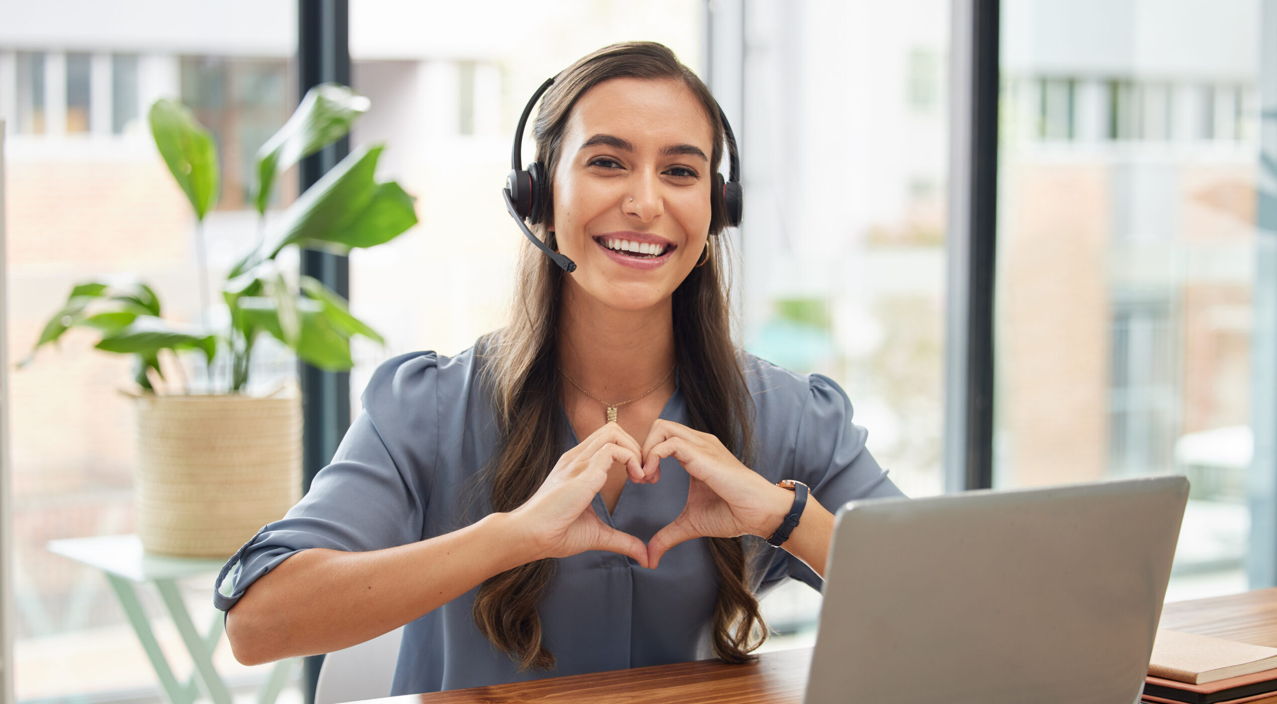 Frau, Call-Center und Laptop mit Herz Geste für Telemarketing, Kundenservice oder Unterstützung im Büro.